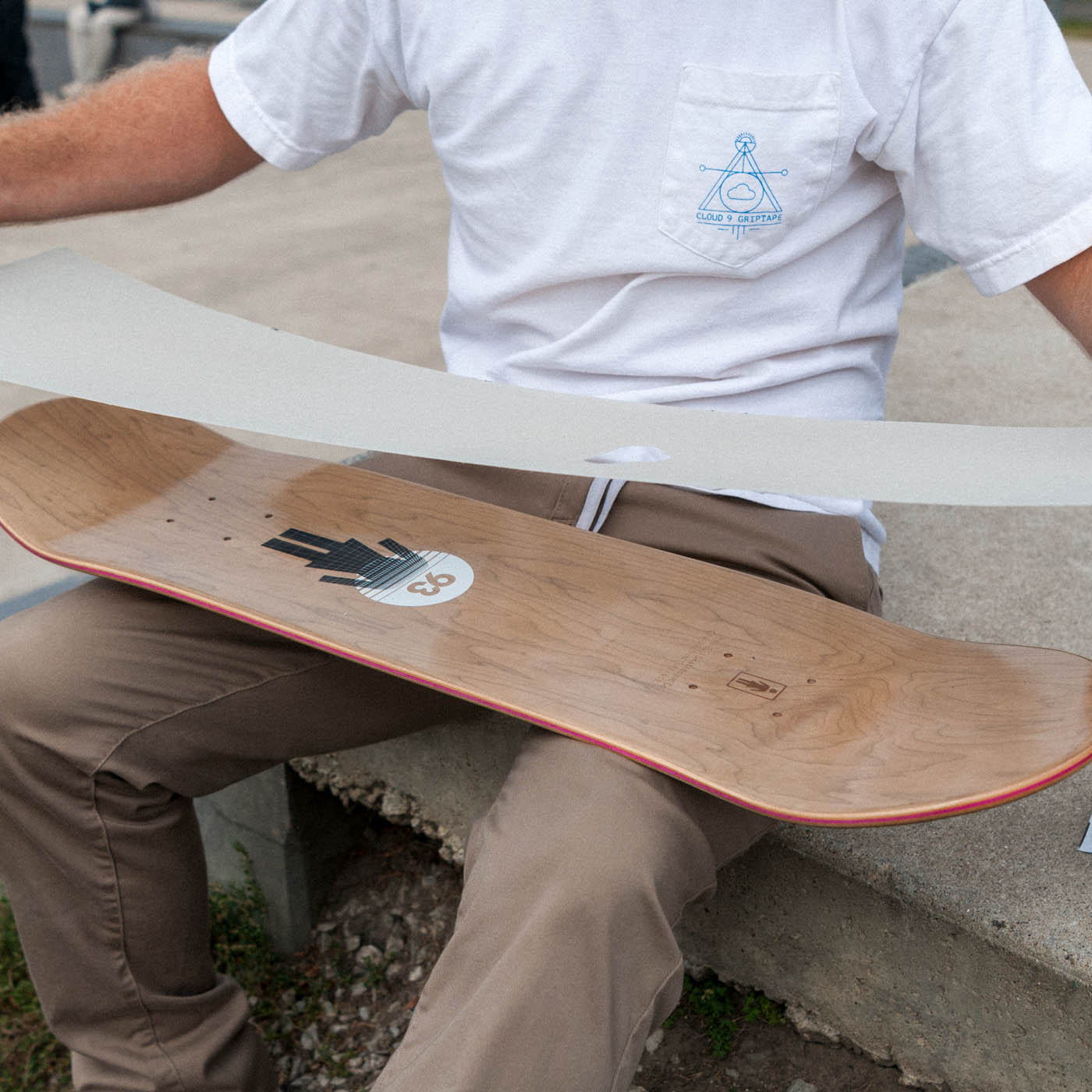 Placing the grip tape onto the board before pressing it into place.