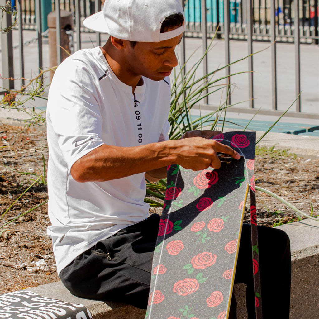 Jean-Marc Johanne setting up rose grip tape on a new skateboard.